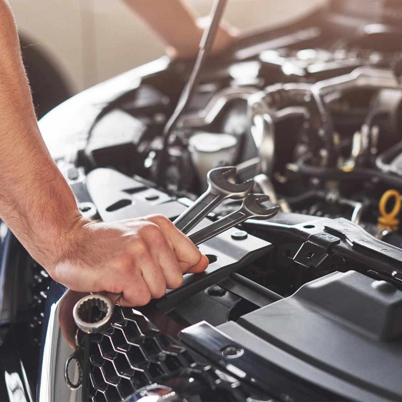 Picture showing muscular car service worker repairing vehicle